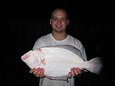 Adam Marianski holding a large Floridian gulf flounder<em> (Paralichthys albiguttata)</em>.