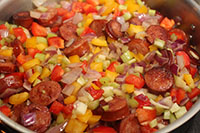 Chopped onions, bell pepper and celery is added and briefly pan-fried